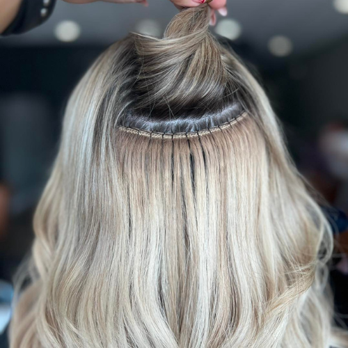 2 | Rawe Beauty Picture of a woman with black hair, having hair extensions sewn into her hair